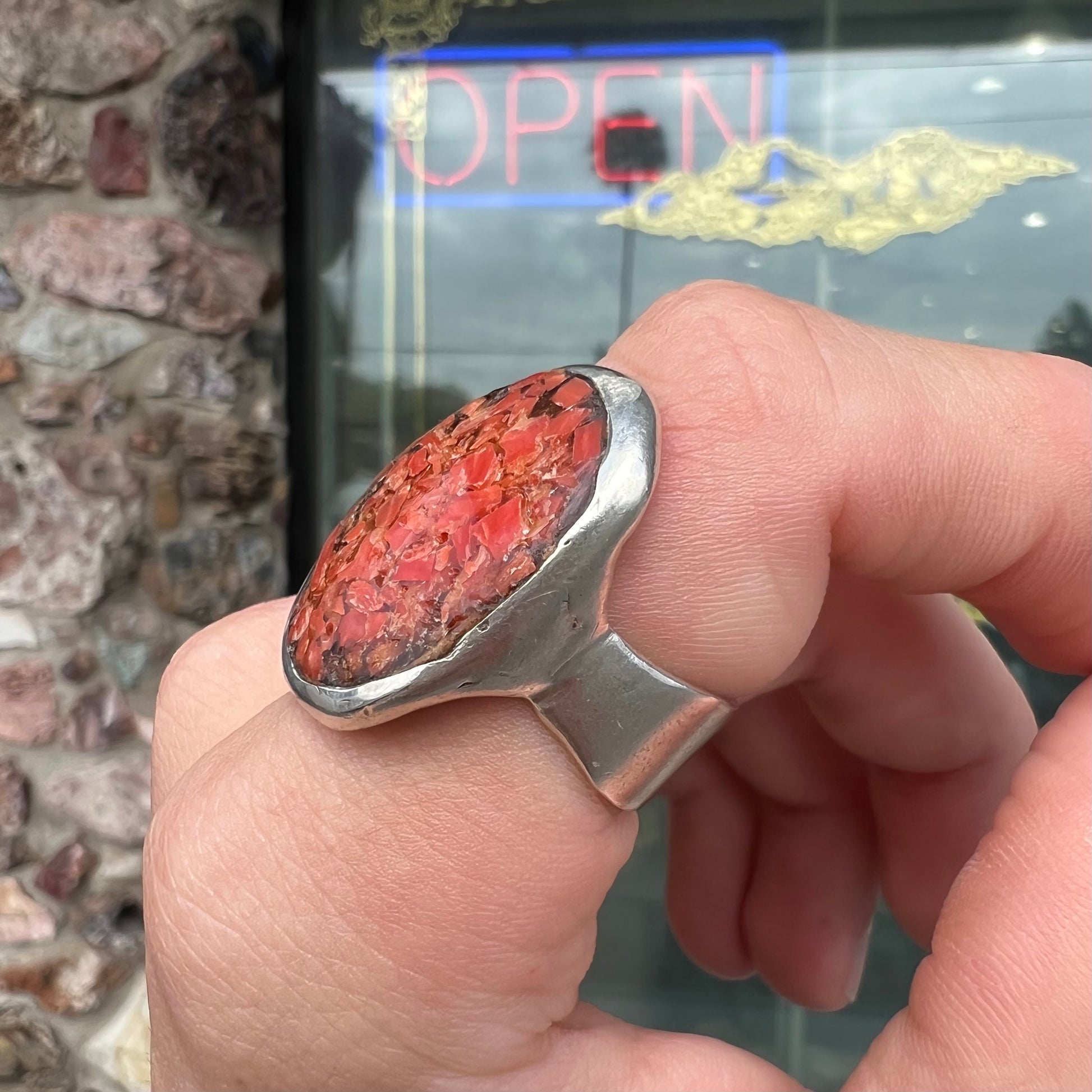 A rustic style, handmade silver men's ring set with crushed red coral.