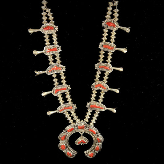 A Navajo style squash blossom necklace set with red coral branches, handmade by artist Delbert Chatter.