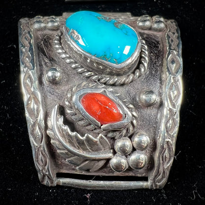 A pair of Navajo made sterling silver watch cuffs set with turquoise and coral stones.