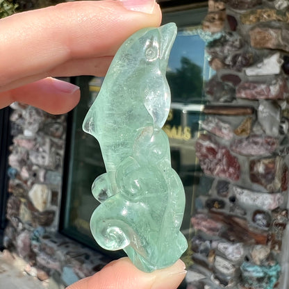 A dolphin carved by artist, Ron Stevens, from a blue aquamarine crystal.