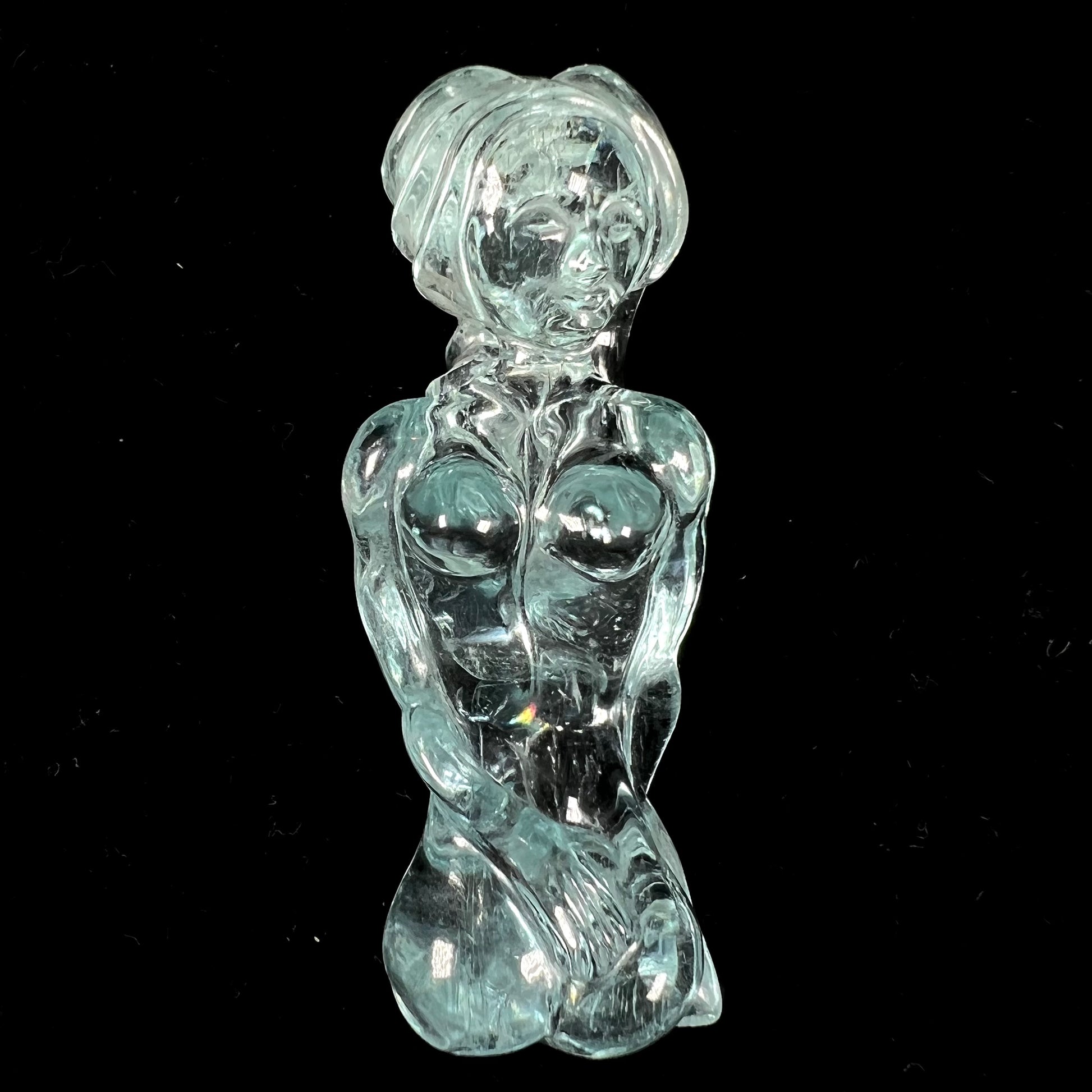 A stone woman figure carved from a blue aquamarine crystal.  The piece resembles Venus Gummi de Milo.