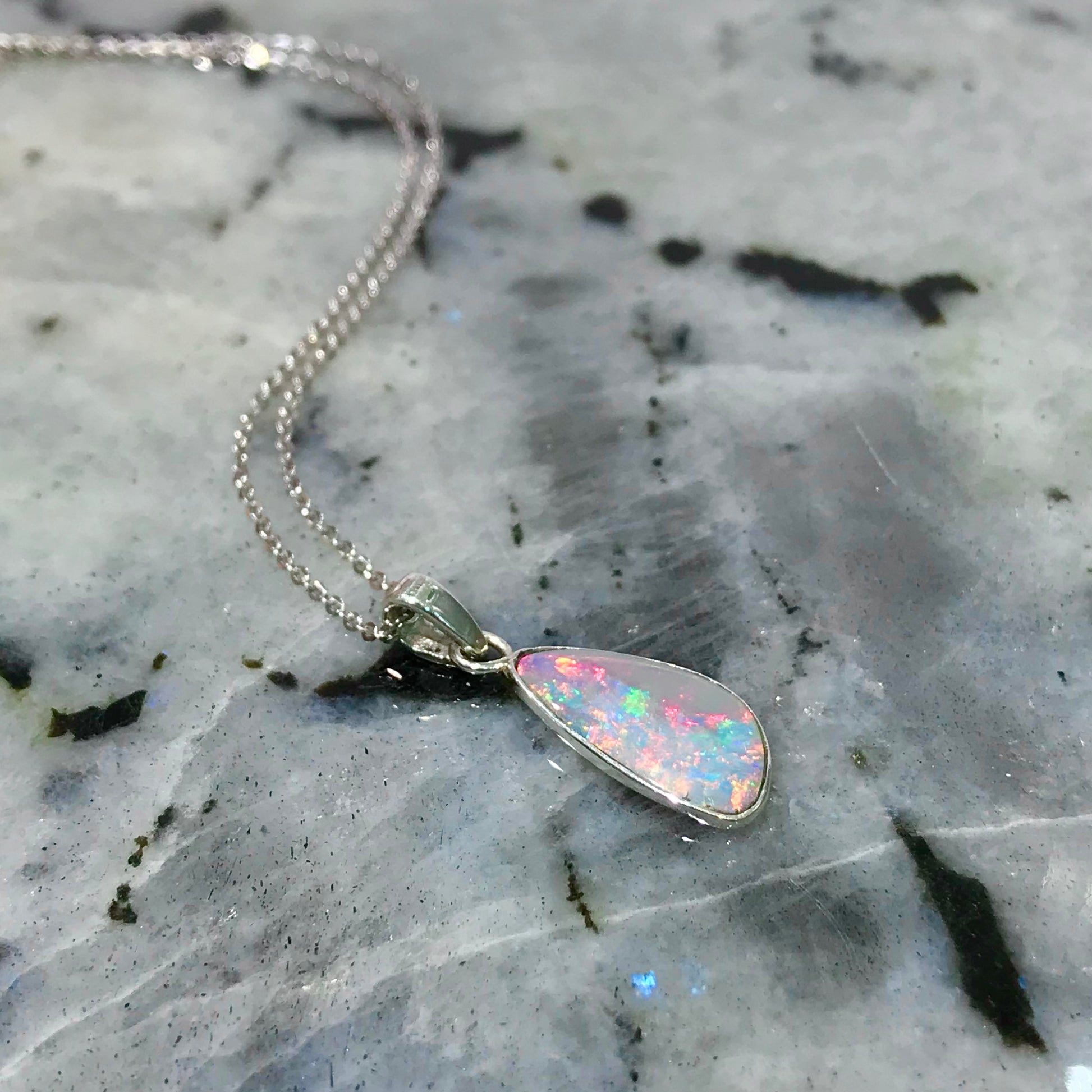 A handmade Lightning Ridge white crystal opal pendant on a sterling silver cable chain.