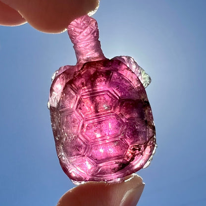 A crystal turtle carved from a pink tourmaline stone.