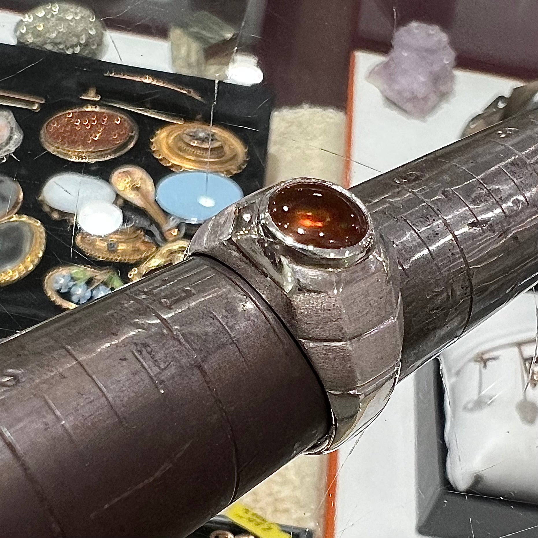 A round cabochon cut red and green fire agate set in a brushed metal white gold men's ring.