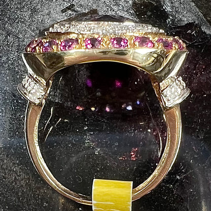 A yellow gold garnet and diamond halo ring set with a checkerboard cut rhodolite garnet center stone.