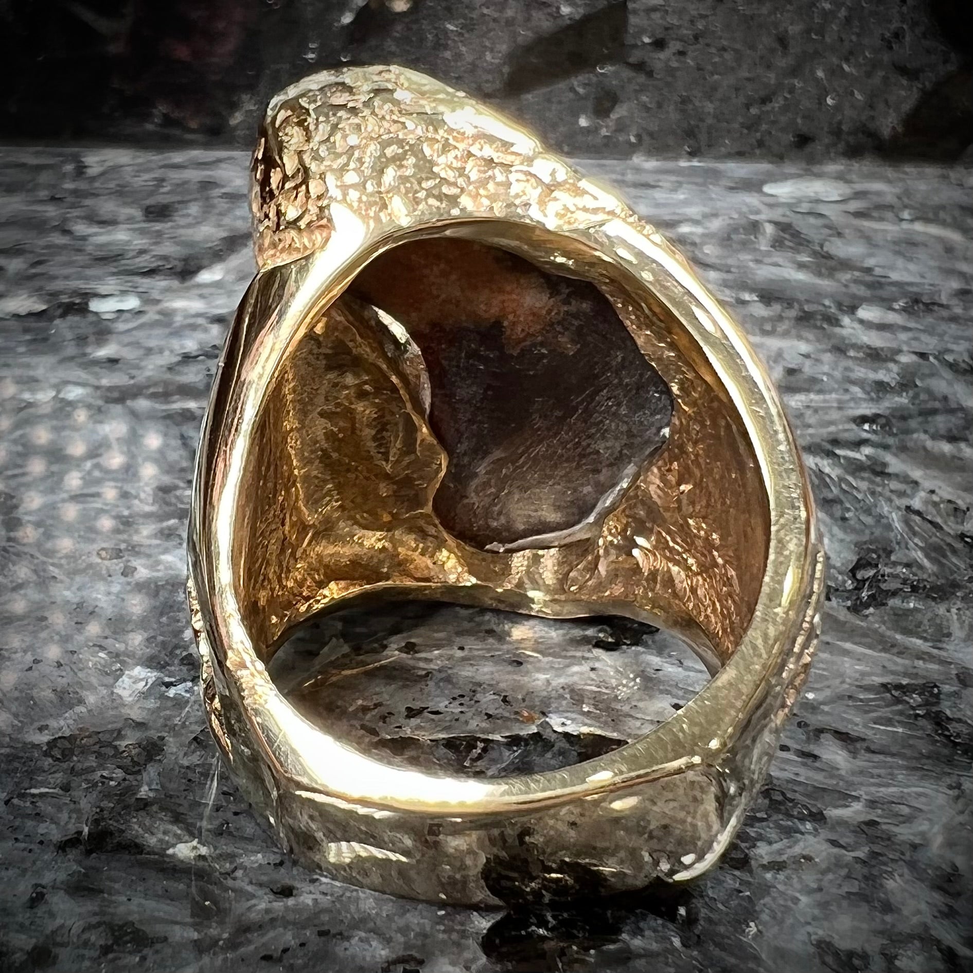 A men's Deer Creek fire agate solitaire ring cast in yellow gold.  The stone is predominantly purple.