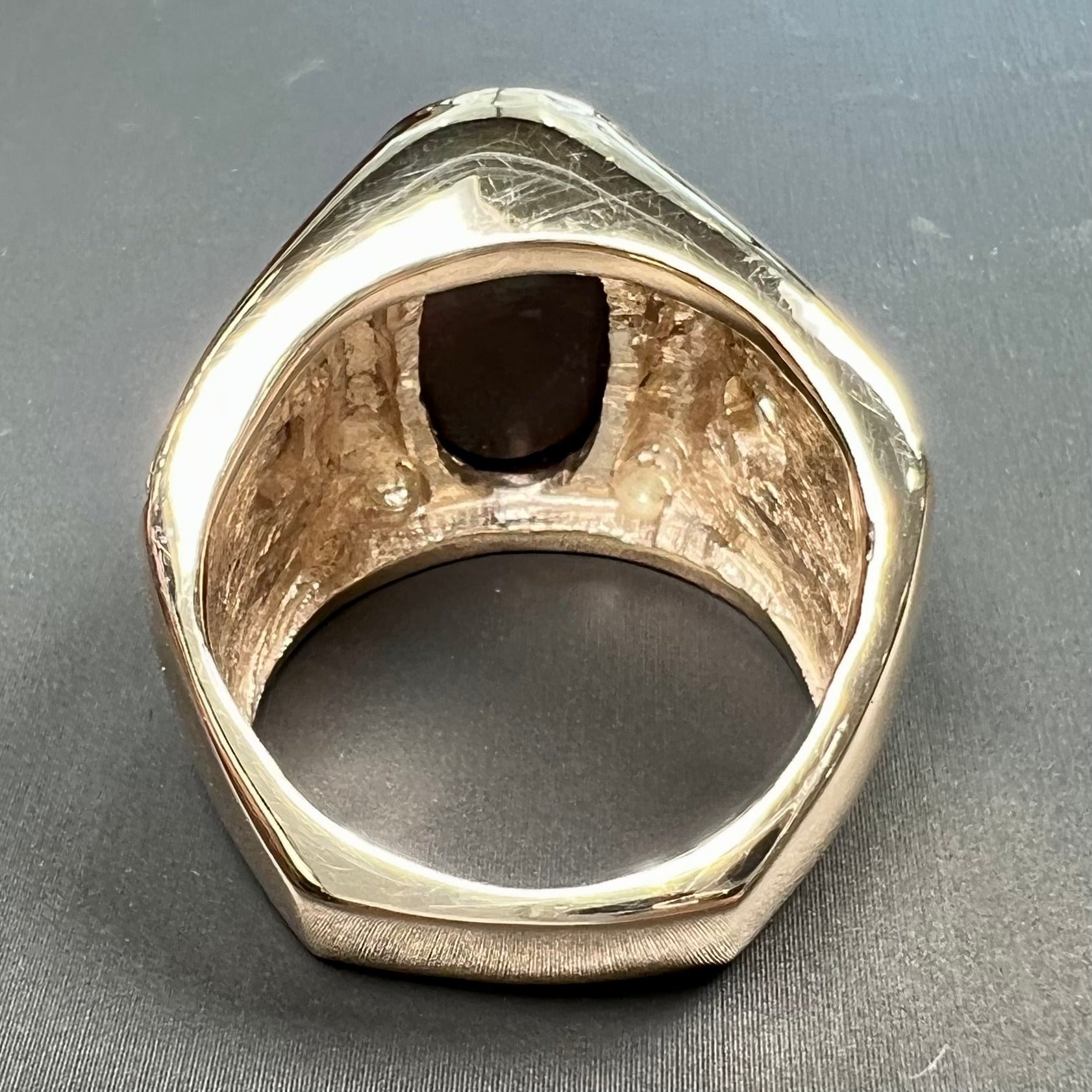 A men's solid yellow gold fire agate and diamond ring.  The fire agate displays predominantly red and green.