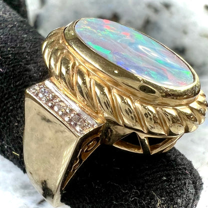 A ladies' Lightning Ridge semi-black opal ring cast in yellow gold and set with diamond accents.