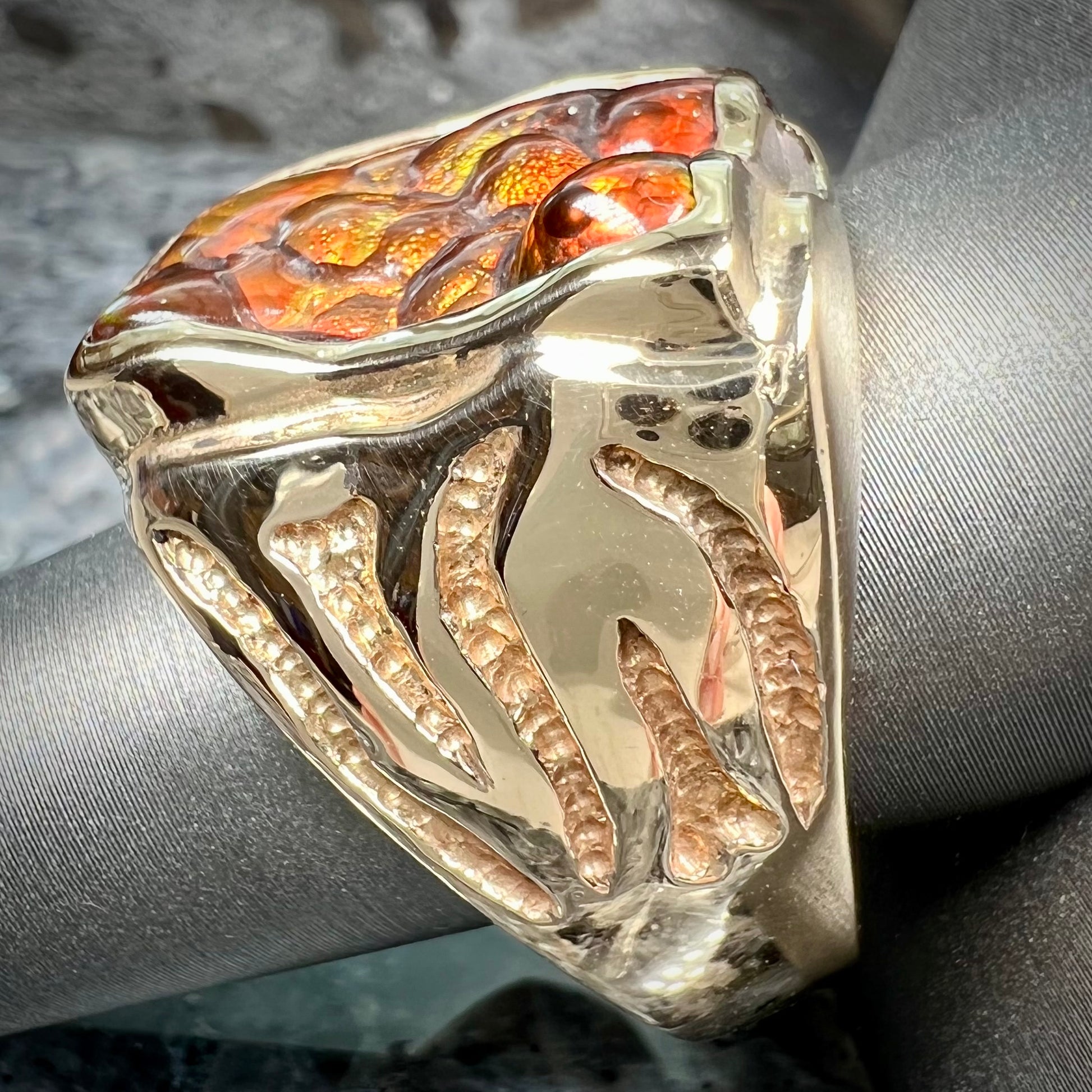 A men's custom fire agate solitaire ring cast in yellow gold.