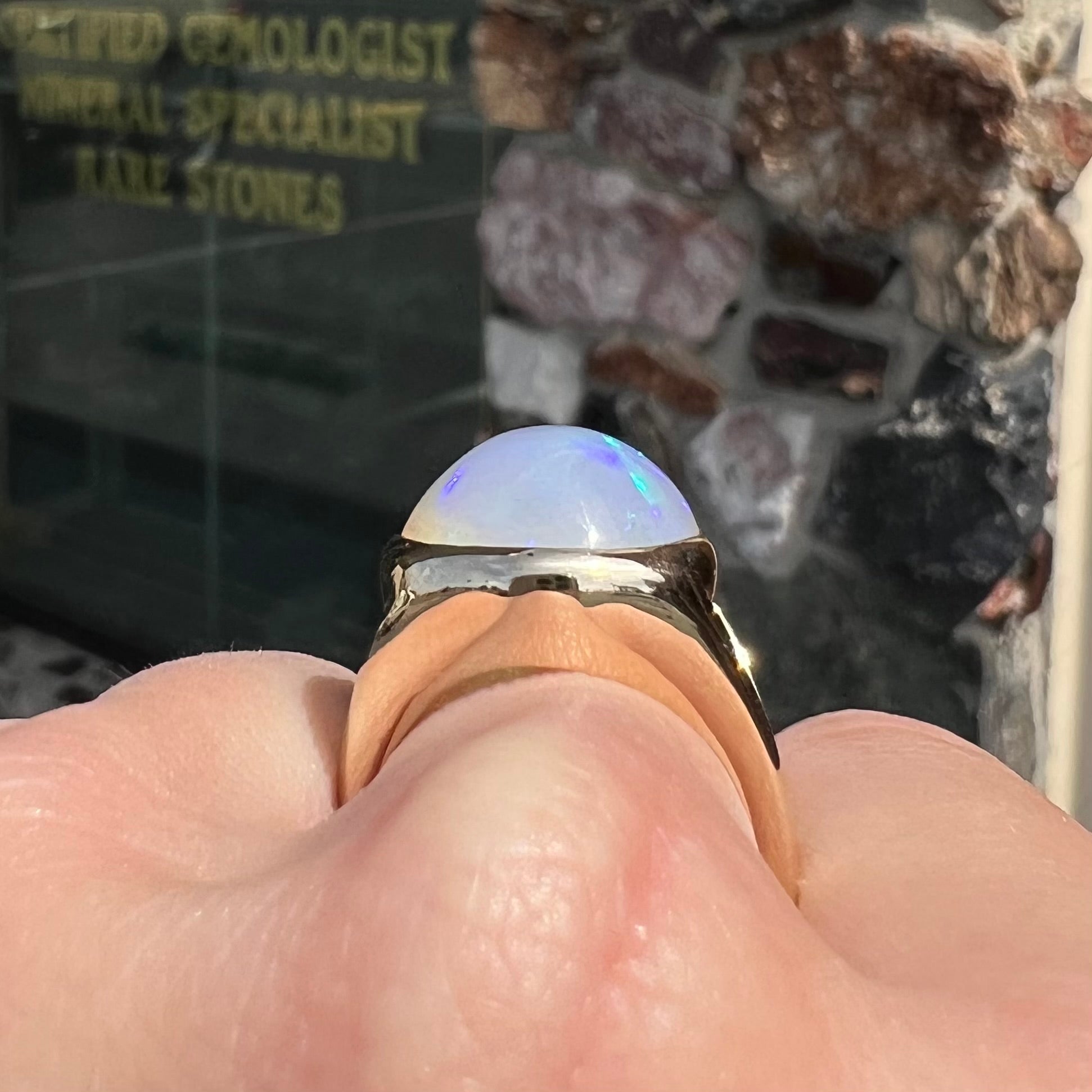 A gold split shank solitaire ring set with an oval cabochon cut 16.83 carat Ethiopian jelly fire opal.