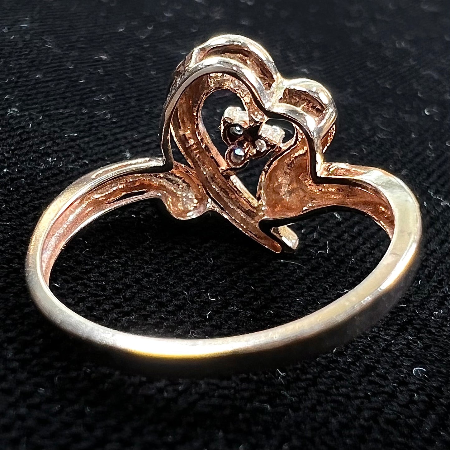 A rose gold heart ring set with three round cut diamonds.