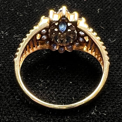 A yellow gold cluster halo ring set with blue sapphire and diamond halos.