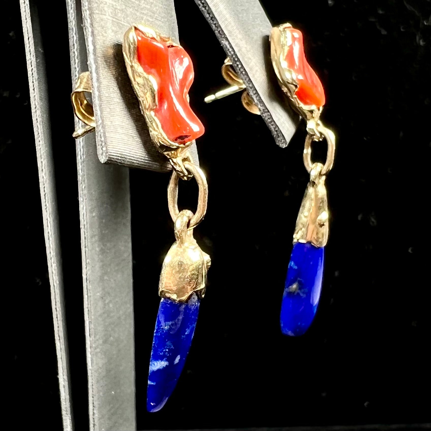 A pair of Navajo-handmade yellow gold dangle earrings set with lapis lazuli and polished coral branches.