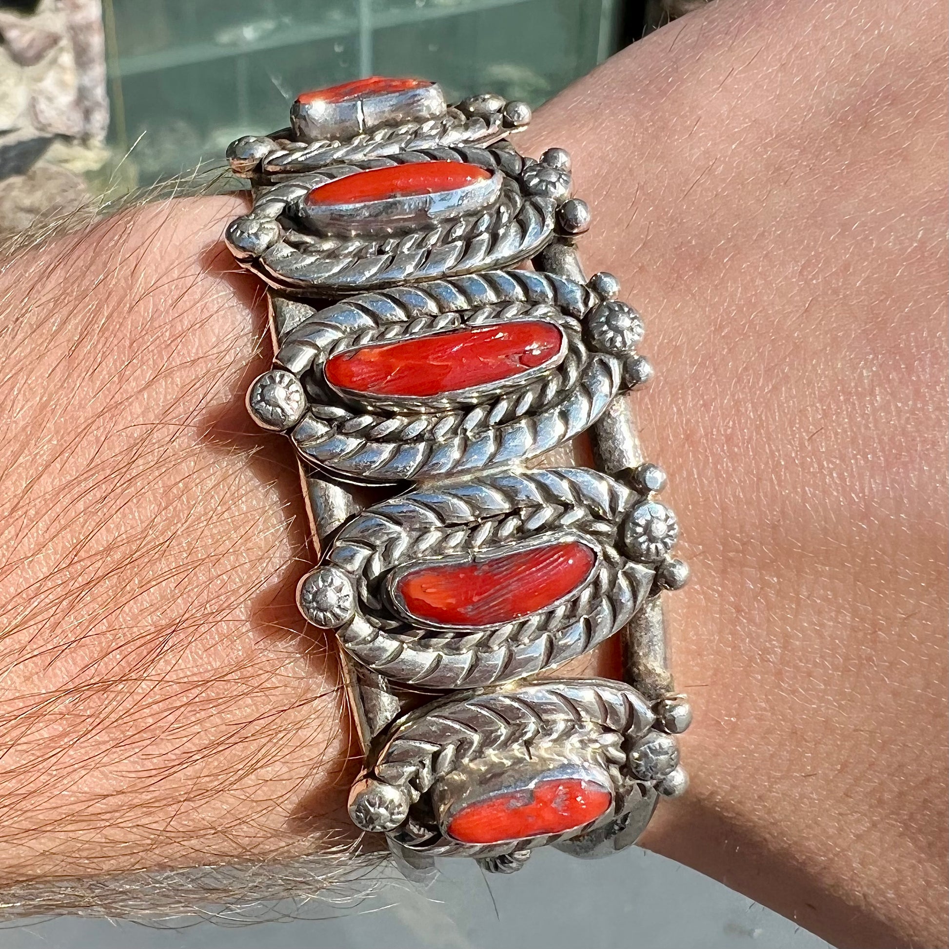 A sterling silver cuff bracelet set with polished coral branches handmade by Navajo artist, Delbert Chatter.