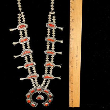 A Navajo style squash blossom necklace set with red coral branches, handmade by artist Delbert Chatter.