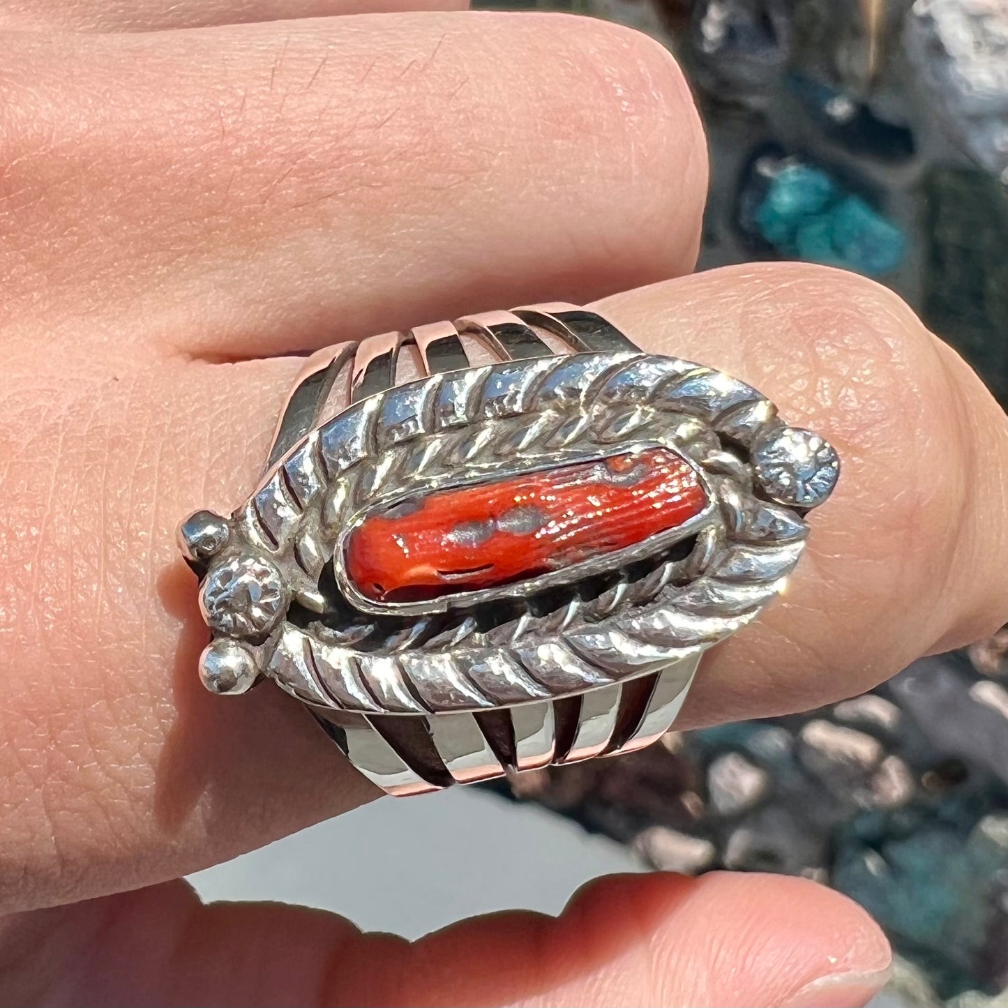 A sterling silver ring set with a polished red coral branch handmade by Navajo artist, Delbert Chatter.