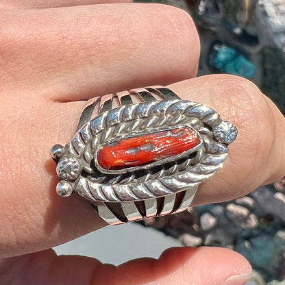 A sterling silver ring set with a polished red coral branch handmade by Navajo artist, Delbert Chatter.