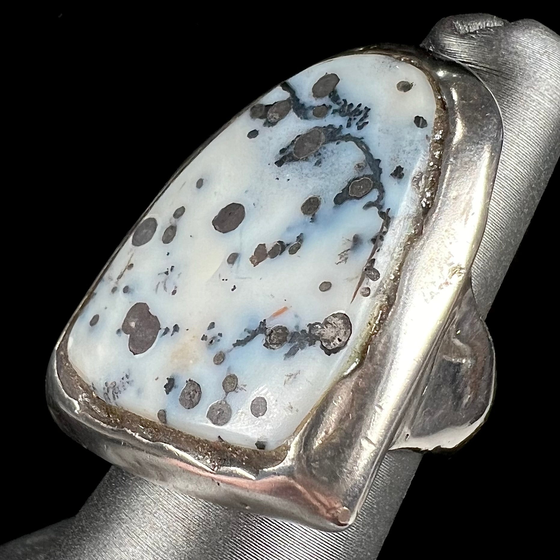 A bezel set ring handmade in sterling silver with a white dendritic agate stone.
