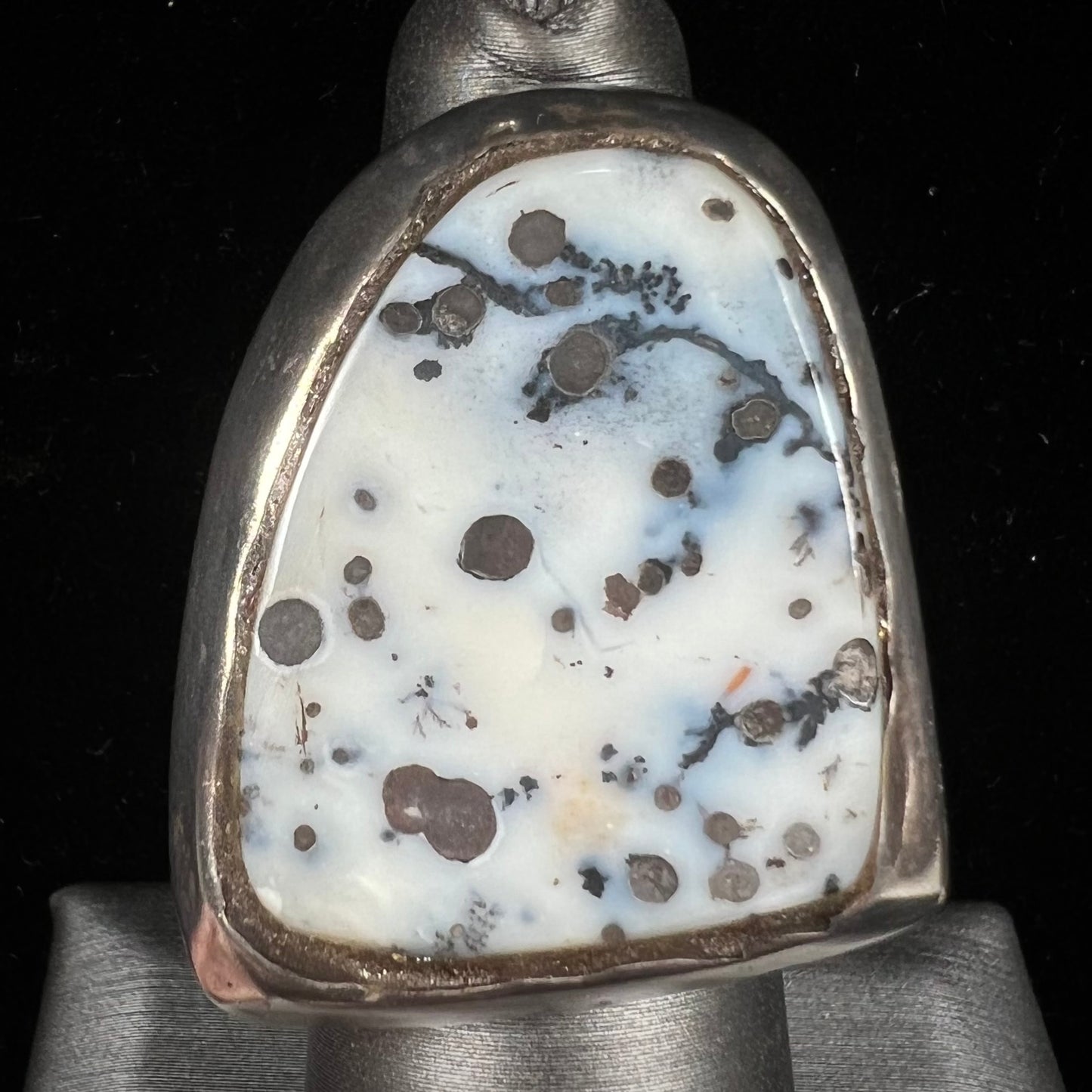 A bezel set ring handmade in sterling silver with a white dendritic agate stone.
