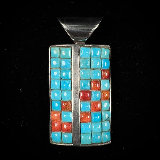 A silver pendant set with square cabochon cut turquoise and coral stones.  The piece is stamped "DTR CHINA".