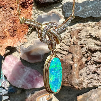 A gold black opal and diamond necklace.  There are round, princess cut, and baguette cut diamonds.