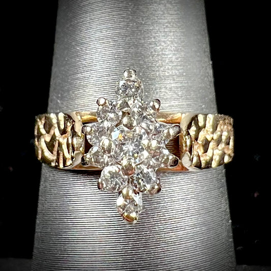 A ladies' estate diamond cluster ring cast in yellow gold.  The shank has a nugget design.