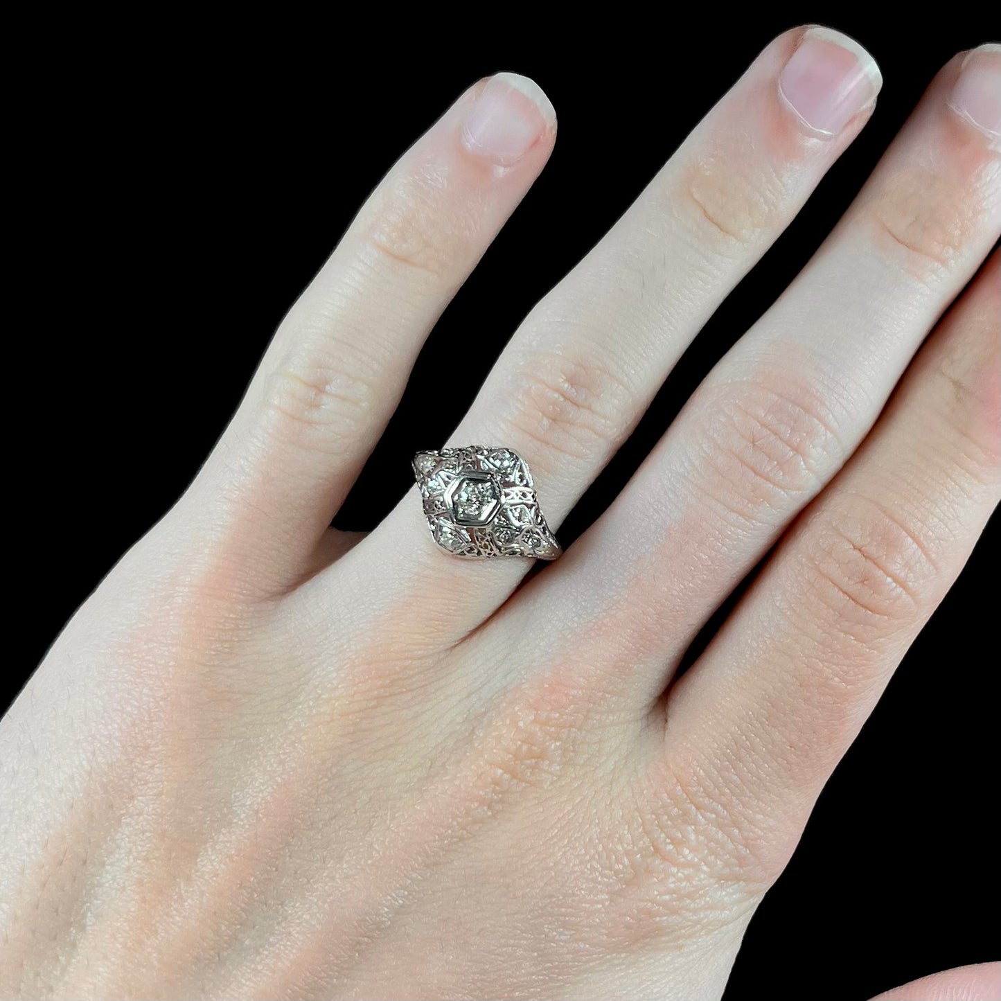 An antique ladies' platinum diamond filigree engagement ring.  The center stone is an old European cut diamond.