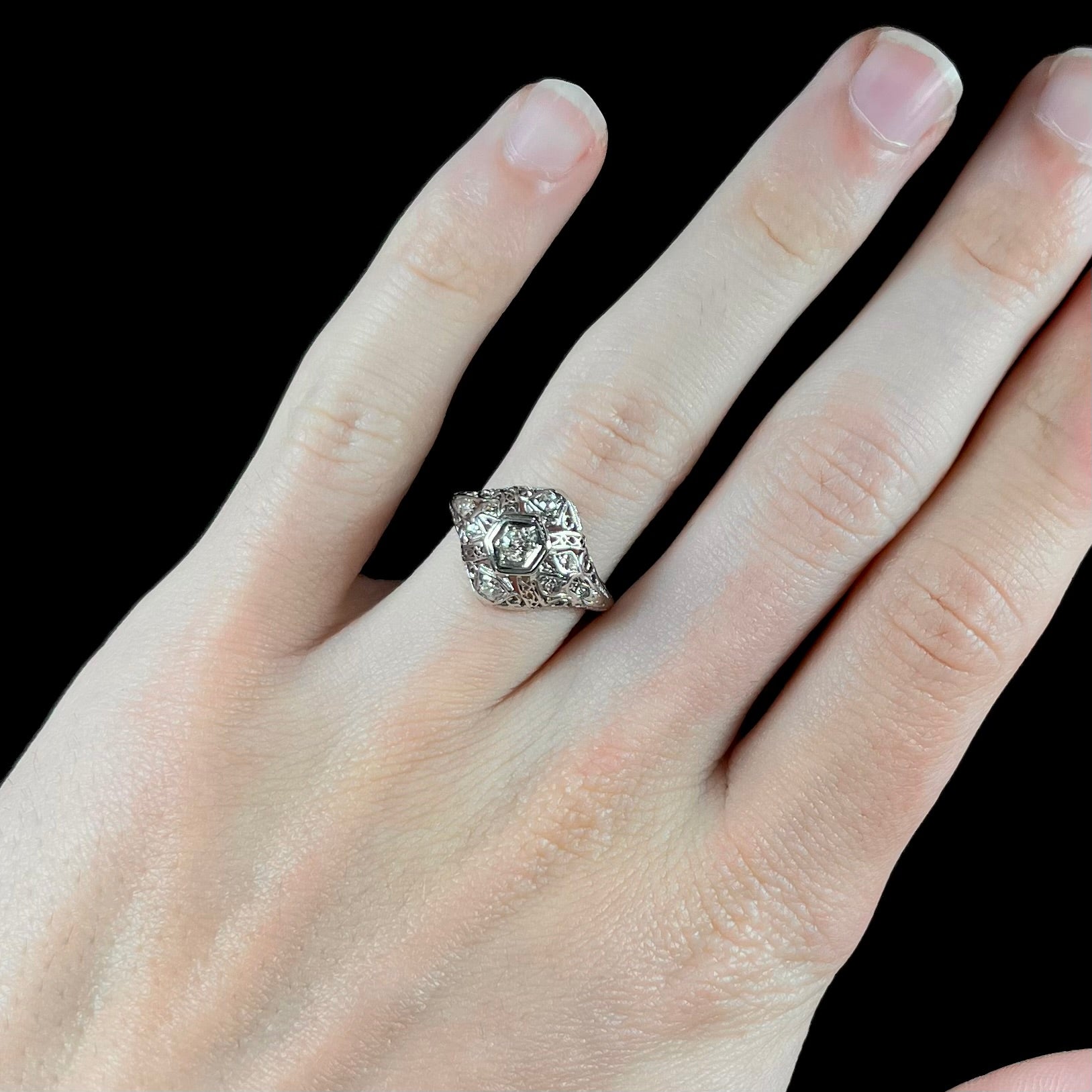 An antique ladies' platinum diamond filigree engagement ring.  The center stone is an old European cut diamond.