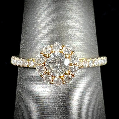 A ladies' diamond halo engagement ring cast in yellow gold.  The center stone is a 0.19ct round cut natural diamond.