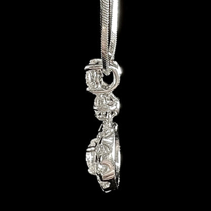 A ladies' diamond halo necklace with snake chain cast in platinum.