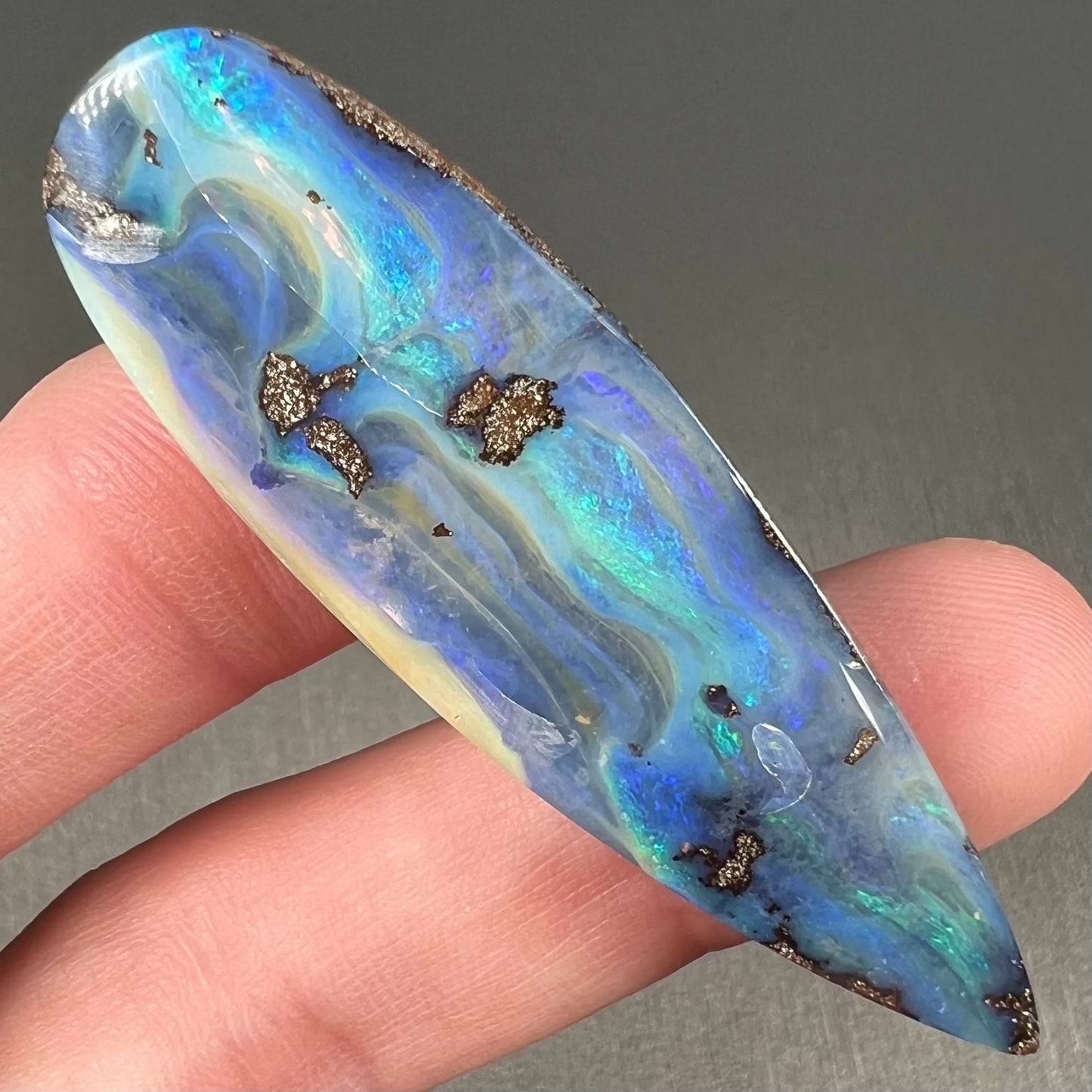 A blue, drop shaped Quilpie boulder opal stone from Queensland, Australia.