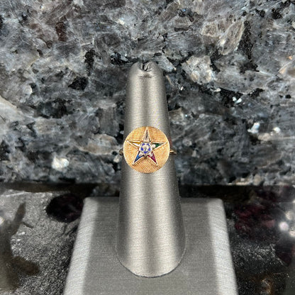 A gold ring set with multicolored synthetic sapphires forming a star with a blue enameled center, symbolizing the Order of the Eastern Star.