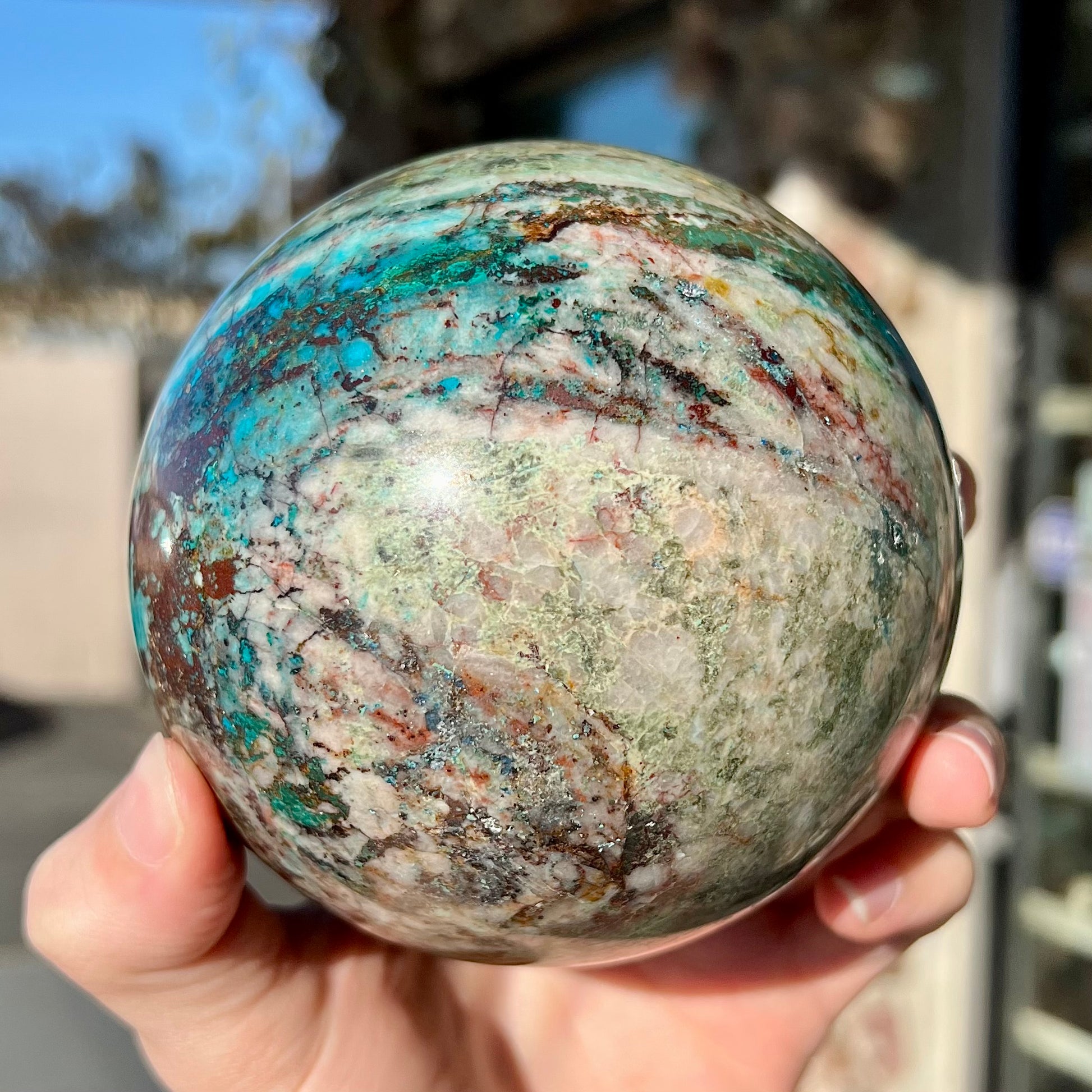 A stone sphere cut from Eilat Stone, mined in Israel.  Material contains turquoise, chrysocolla, azurite, malachite, and cuprite.