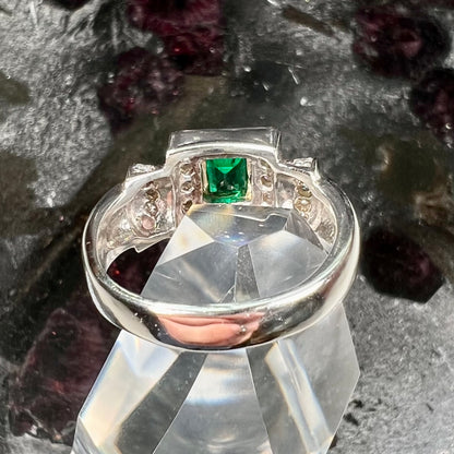 A two tone gold emerald and diamond halo ring.