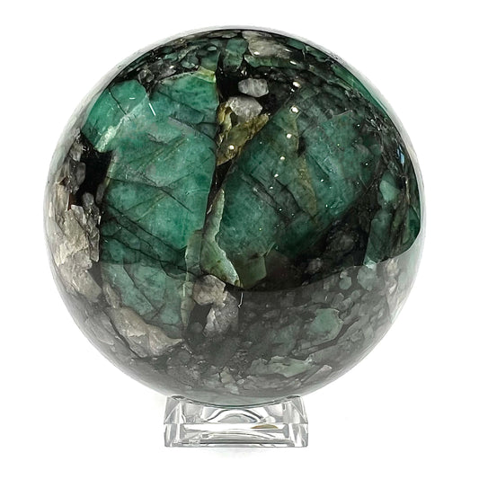 A gemstone sphere carved from a natural emerald crystal specimen, measuring 2.2 inches in diameter.