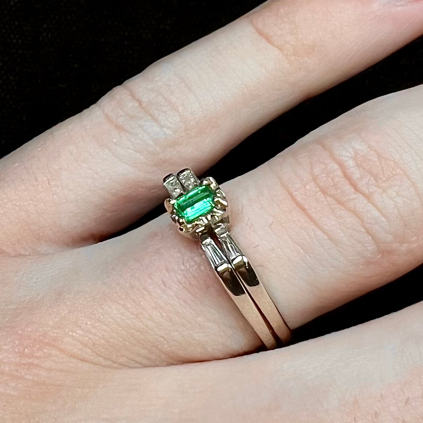 A white gold emerald and baguette cut diamond engagement and wedding set.