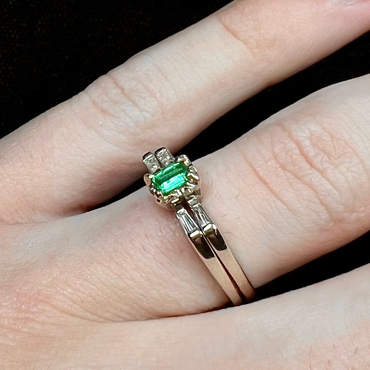 A white gold emerald and baguette cut diamond engagement and wedding set.