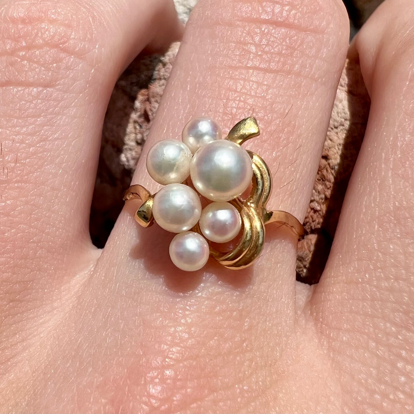 A yellow gold Akoya pearl cluster ring.  The pearls are round with pink overtones and resemble bubbles.