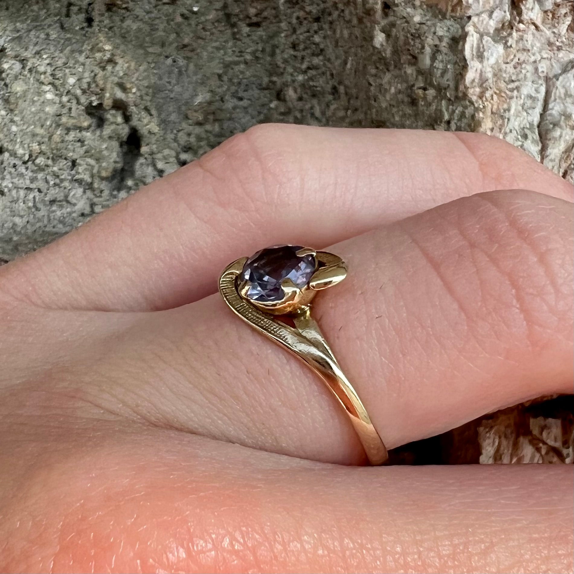 A vintage 1960's yellow gold ring set with a round synthetic purple alexandrite.  The prongs are worn.