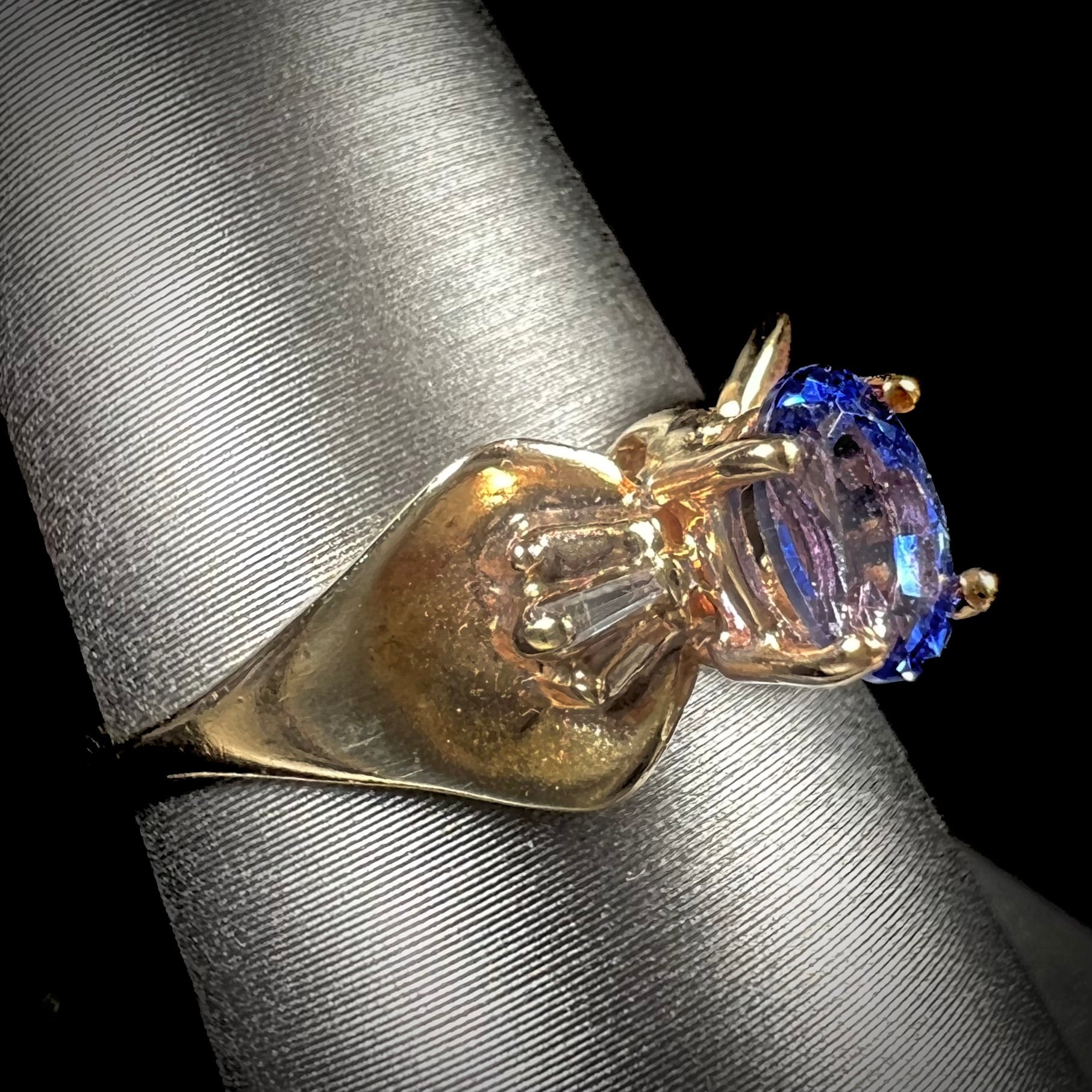 A natural blue sapphire and diamond baguette ring cast in yellow gold.
