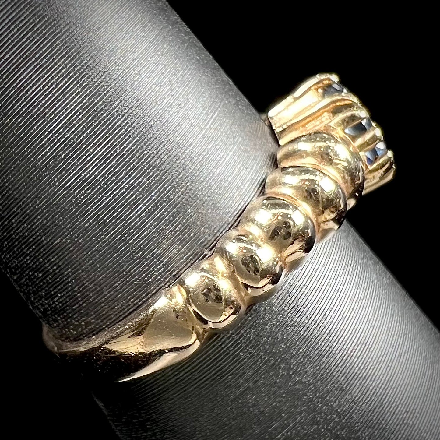 A ladies' yellow gold cluster ring set with round blue sapphires and a round diamond.