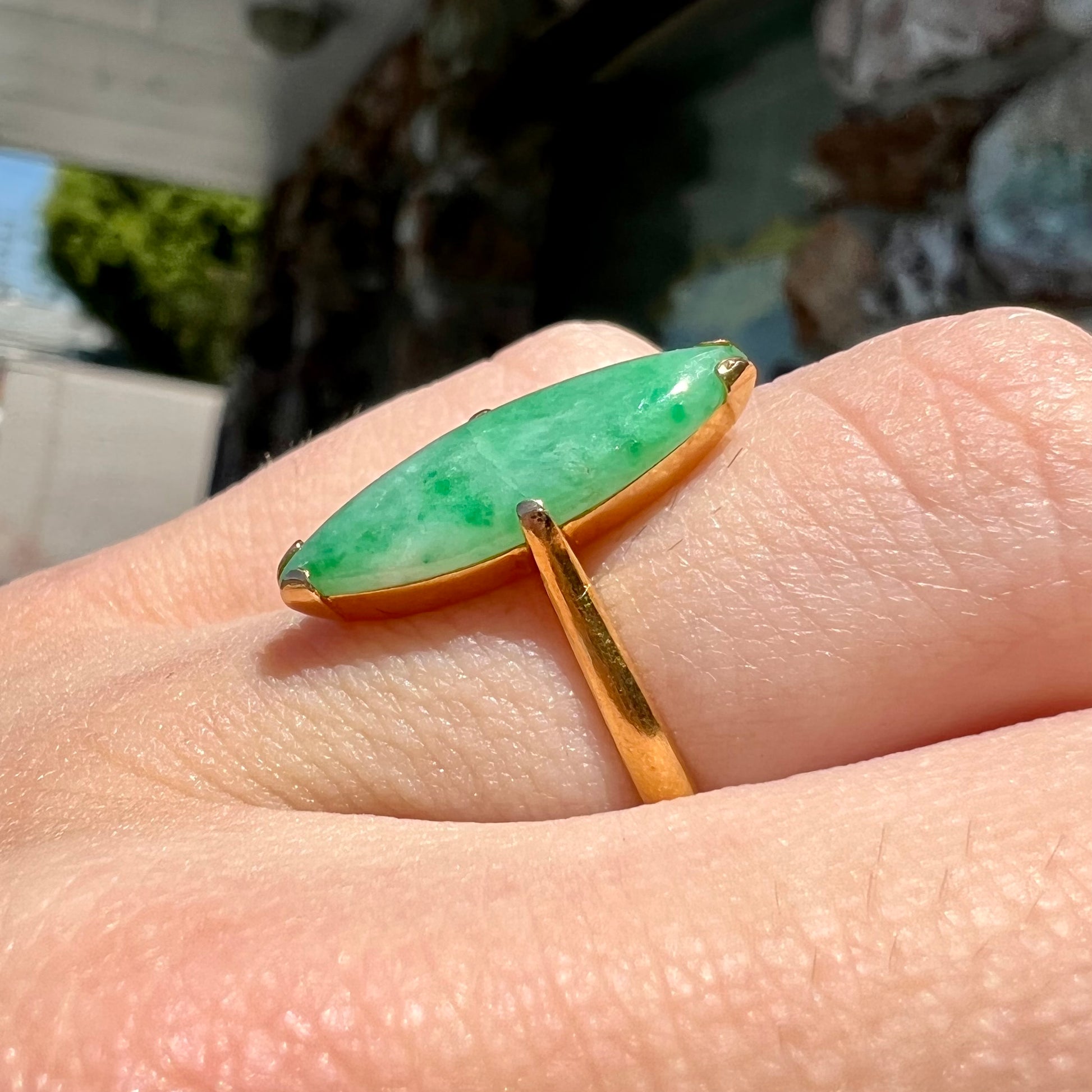 A 22 karat yellow gold solitaire ring set with a marquise cabochon cut green jadeite.