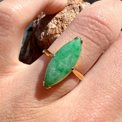 A 22 karat yellow gold solitaire ring set with a marquise cabochon cut green jadeite.