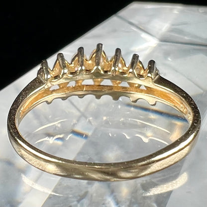 An estate yellow gold ring prong set with seven marquise cut diamonds.