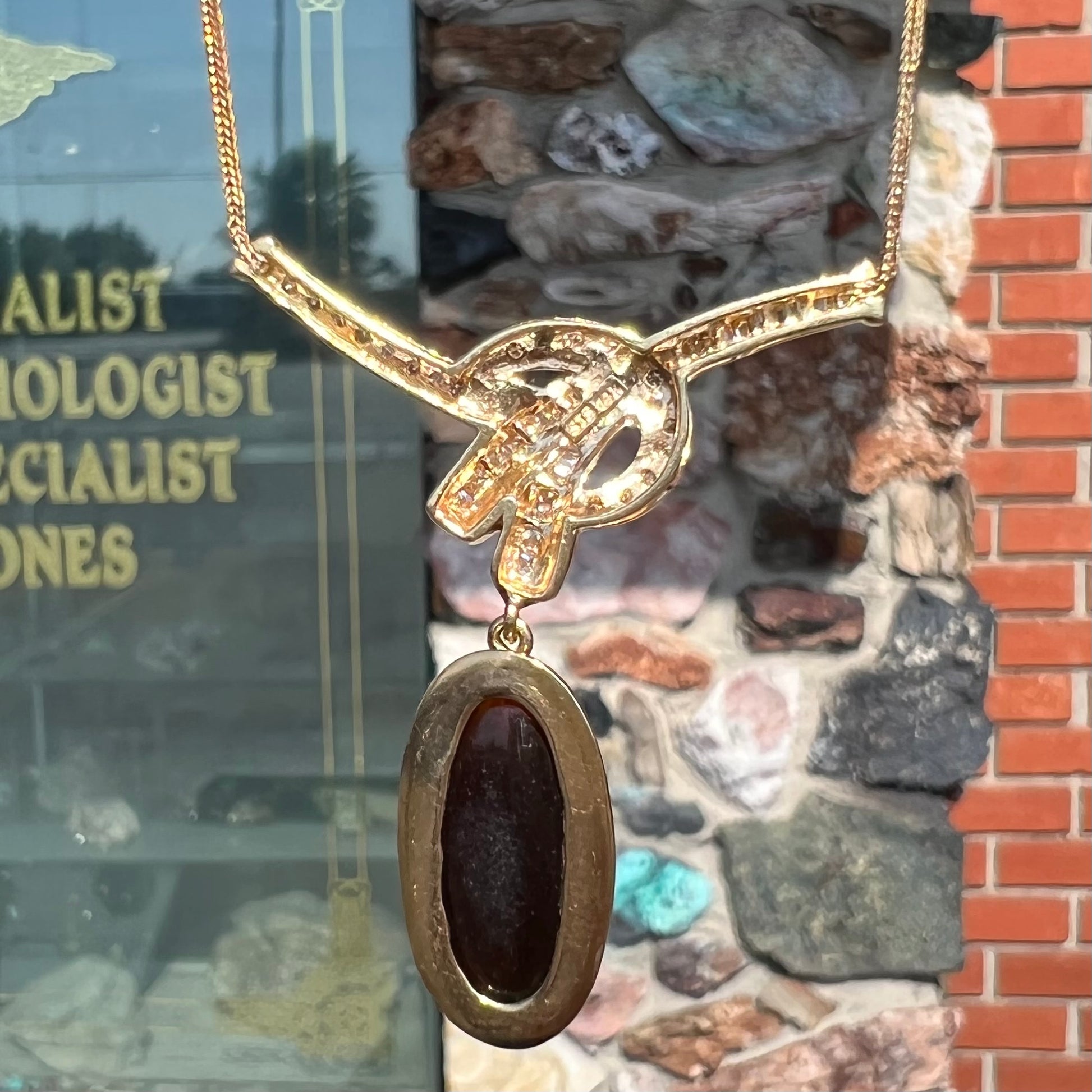 A gold black opal and diamond necklace.  There are round, princess cut, and baguette cut diamonds.
