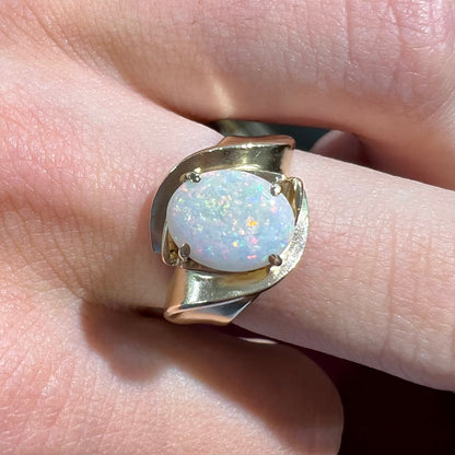 An estate gold white crystal opal solitaire ring.  There are some scratches on the gold.