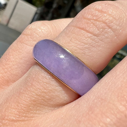 A stone ring carved from purple jadeite jade and mounted on a gold band.