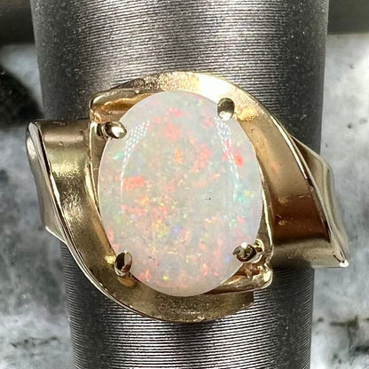 An estate gold white crystal opal solitaire ring.  There are some scratches on the gold.