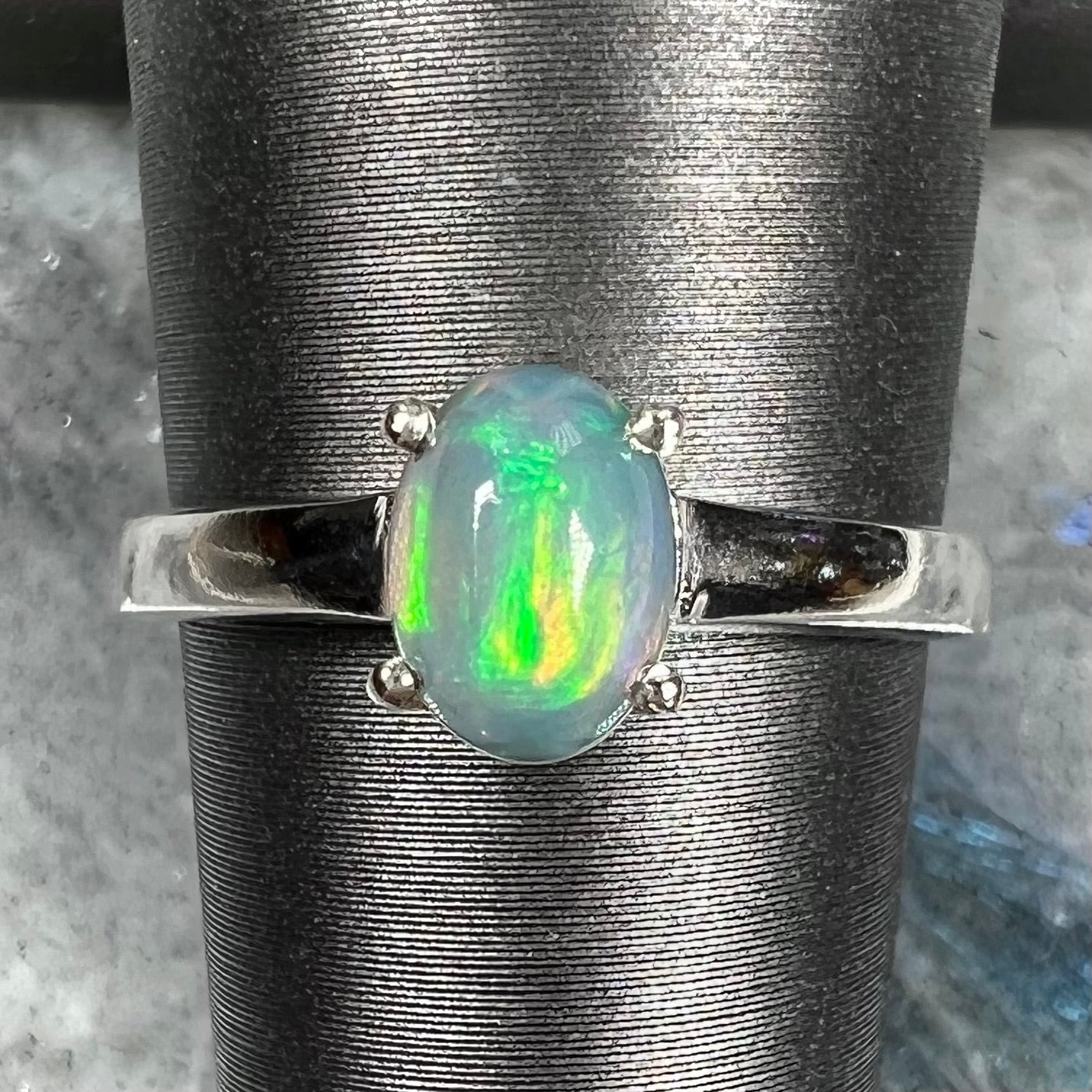A silver, prong set, oval cabochon cut Ethiopian opal solitaire ring.