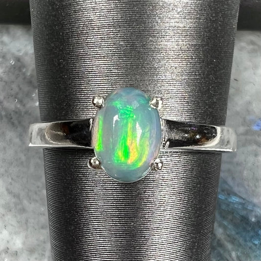 A silver, prong set, oval cabochon cut Ethiopian opal solitaire ring.